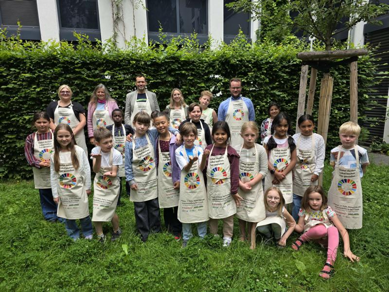 Sind stolz auf das erste internationale Heidelberger Kinderkochbuch (hintere Reihe von links): Rikea Grabs (Bereichsleiterin Ferienbetreuung bei päd-aktiv), Sabine Lachenicht (Leiterin Amt für Umweltschutz, Gewerbeaufsicht und Energie), Jens Katzenberger (Vorstand bei päd-aktiv), Barbara von der Heyden (Digitalisierung/Übergang Kita-Schule beim Amt für Schule und Bildung) und Thorsten Erbismann (Agenda-Büro beim Amt für Umweltschutz, Gewerbeaufsicht und Energie).